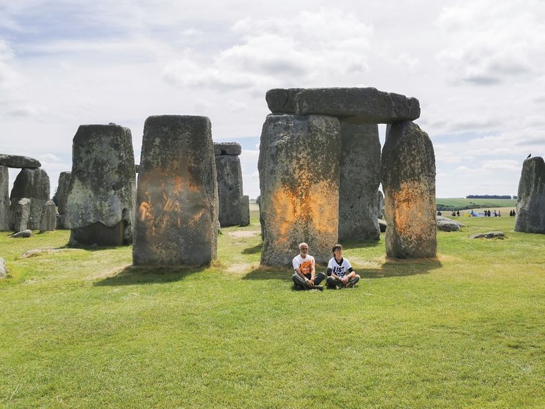 En esta fotografía se muestran unos manifestantes del grupo Just Stop Oil tras rociar pintura naranja en el monumento de Stonehenge, en Salisbury, Inglaterra, el miércoles 19 de junio de 2024. (Just Stop Oil vía AP)