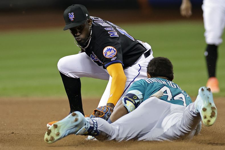El dominicano Ronny Mauricio, intermedista de los Mets de Nueva York, pone out a su compatriota Julio Rodríguez, de los Marineros de Seattle, el viernes 1 de septiembre de 2023 (AP Foto/Adam Hunger)