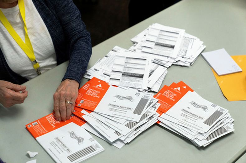 ARCHIVO - Un miembro del personal electoral toma una boleta sin abrir durante el proceso de clasificación en la oficina electoral del condado de Clackamas, en Oregon City, Oregon, el 7 de noviembre de 2024. (AP Foto/Jenny Kane/Archivo)