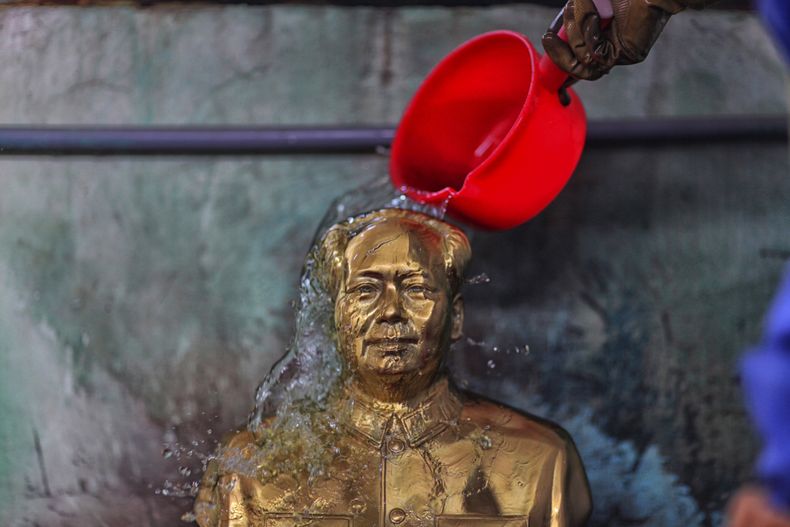 Un trabajador vierte agua en una estatua de Mao Tse-tung en una f&aacute;brica especializada en hacer bustos y esculturas del fallecido l&iacute;der chino en Shaoshan, el pueblo natal de Mao, en Hunan, en el sur de China, el 5 de diciembre de 2013. El 26