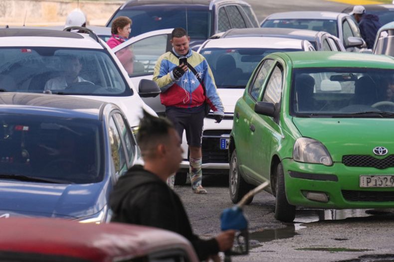 Un hombre con una chaqueta con los colores de la bandera de Venezuela hace fila para comprar combustible en una gasolinera, el viernes 6 de febrero de 2026, en La Habana, Cuba. (AP Foto/Ramón Espinosa)
