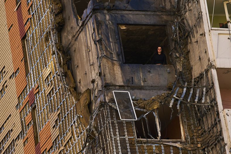 Una mujer mira por la ventana de un edificio residencial dañado por un un ataque ruso de dron en Kiev, Ucrania, el miércoles 9 de septiembre de 2026. (AP Foto/Francisco Seco)