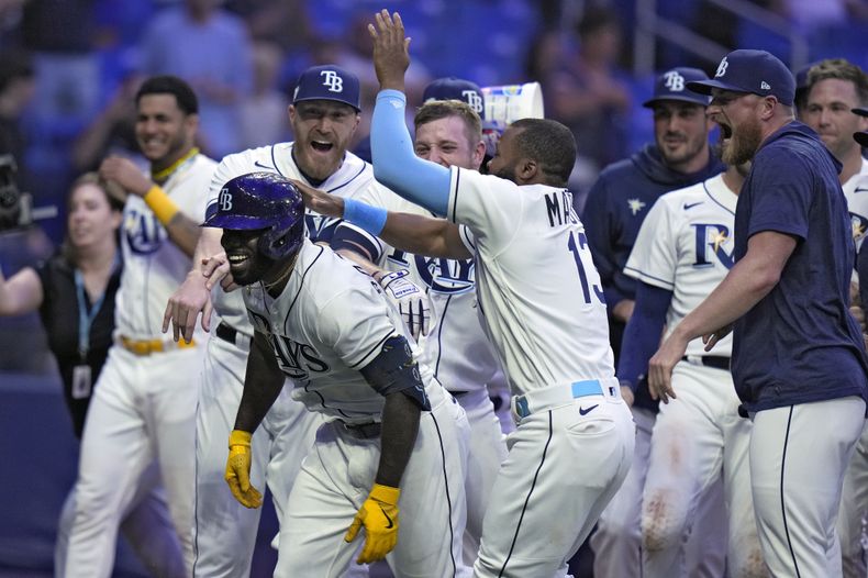 El mexicano Randy Arozarena (izquierda), de los Rays de Tampa Bay, es felicitado por sus compañeros tras batear el jonrón del triunfo sobre los Mellizos de Minnesota, el miércoles 7 de junio de 2023 (AP Foto/Chris OMeara)