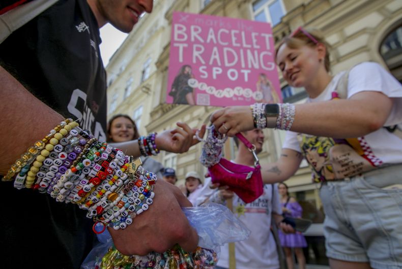 Swifties intercambian brazaletes de la amistad en el cetro de Viena el 8 de agosto de 2024. Los organizadores de tres conciertos de Taylor Swift en un estadio de Viena los cancelaron el miércoles después de dos arrestos por un aparente complot para realizar un ataque contra un evento masivo en el área de Viena como los conciertos. (Foto AP/Heinz-Peter Bader)