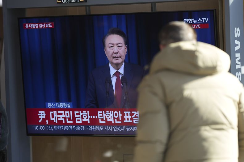 Un hombre observa una pantalla de televisión que muestra la retransmisión en directo del anuncio del presidente surcoreano Yoon Suk Yeol en la estación de ferrocarril de Seúl, Corea del Sur, el sábado 7 de diciembre de 2024. (Foto AP/Lee Jin-man)