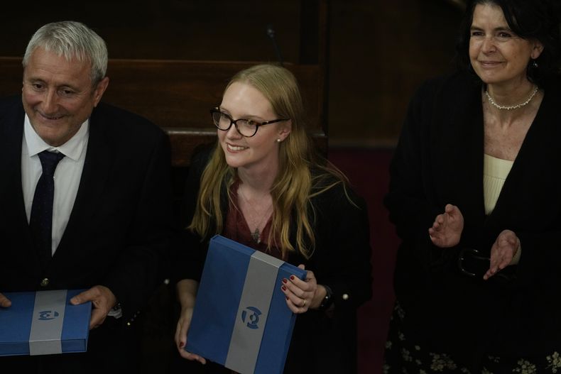 La presidenta del Consejo Constitucional Beatriz Hevia, al centro, y el vicepresidente del Consejo Aldo Valle, a la izquierda, reconocen su elección como presidente y vicepresidente durante la sesión inaugural del consejo que redactará una nueva constitución en el antiguo edificio del Congreso en Santiago, Chile, el miércoles 7 de junio de 2023. (AP Foto/Esteban Félix)