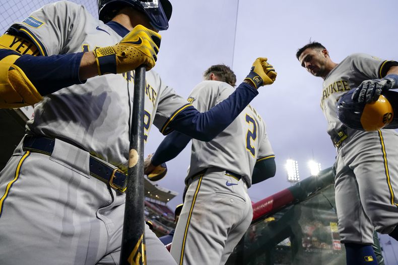 Sal Frelick (derecha) celebra con Christian Yelich (izquierda), su compañero en los Cerveceros de Milwaukee, tras anotar ante los Rojos de Cincinnati, el martes 9 de abril de 2024 (AP Foto/Jeff Dean)