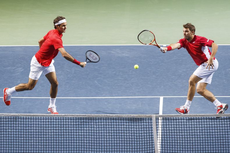 Los jugadores de Suiza, Stanislas Wawrinka, derecha, y Roger Federer, devuelven una pelota contra los kazajos Aleksandr Nedovyesov y Andrey Golubev en los cuartos de final de la Copa Davis el s&aacute;bado, 5 de abril de 2014, en Ginebra. (AP Phtoo/Keysto
