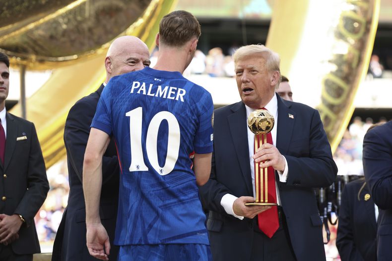 El presidente Donald Trump entrega a Cole Palmer, del Chelsea, el trofeo del Balón de Oro después que Chelsea venció 3-0 al PSG en la final del Mundial de Clubes de la FIFA, en el estadio MetLife en East Rutherford, Nueva Jersey, el domingo 13 de julio de 2025. (Kevin Lamarque/Pool Photo vía AP)