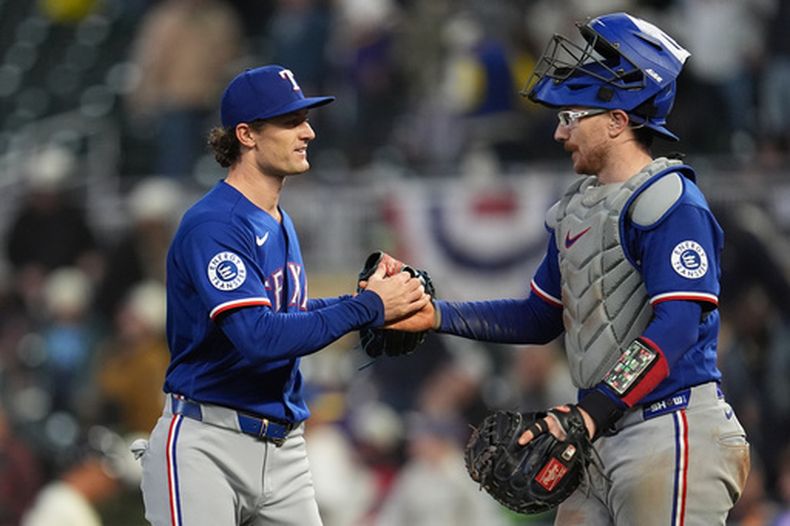 El relevista de los Rangers de Texas Jacob Latz y el cátcher Danny Jansen se dan la mano en el encuentro ante los Mellizos de Minnesota el sábado 26 de septiembre del 2026. (AP Foto/Abbie Parr)