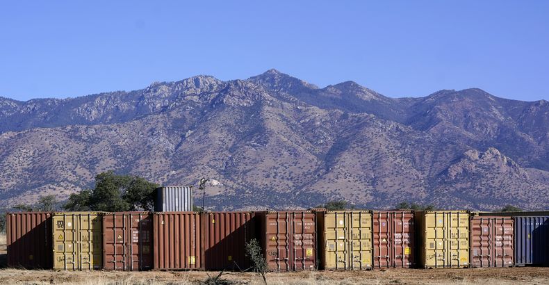 ARCHIVO - Una larga fila de contenedores espera para ser instalada a lo largo de la frontera donde cientos de contenedores crean un muro entre Estados Unidos y México en el Valle de San Rafael, Arizona, el jueves 8 de diciembre de 2022. (AP Foto/Ross D. Franklin)