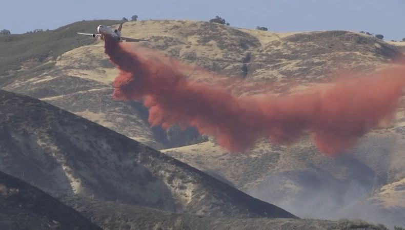 Imagen tomada de video, que muestra a una avioneta arrojando material retardante contra el Incendio Madre en el condado San Luis Obispo en California el 2 de julio del 2025. (KEYT via AP)