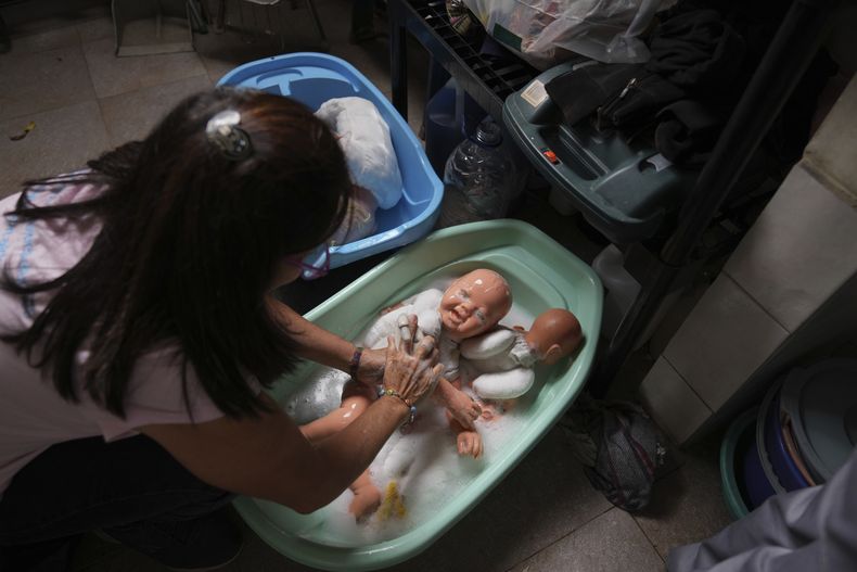 Una voluntaria lava muñecas donadas para entregarlas a niños vulnerables como regalos de Navidad, en la organización sin fines de lucro Hospital de los Peluches, en Caracas, Venezuela, el jueves 5 de diciembre de 2024. (AP Foto/Ariana Cubillos)