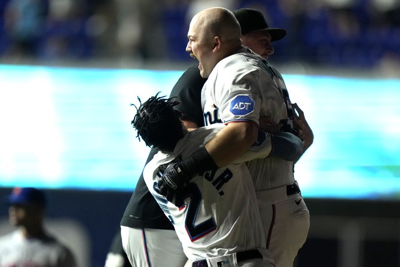 Jake Burger (centro), de los Marlins de Miami, festeja luego de batear el sencillo que definió el juego del martes 19 de septiembre de 2023, ante los Mets de Nueva York (AP Foto/Lynne Sladky)