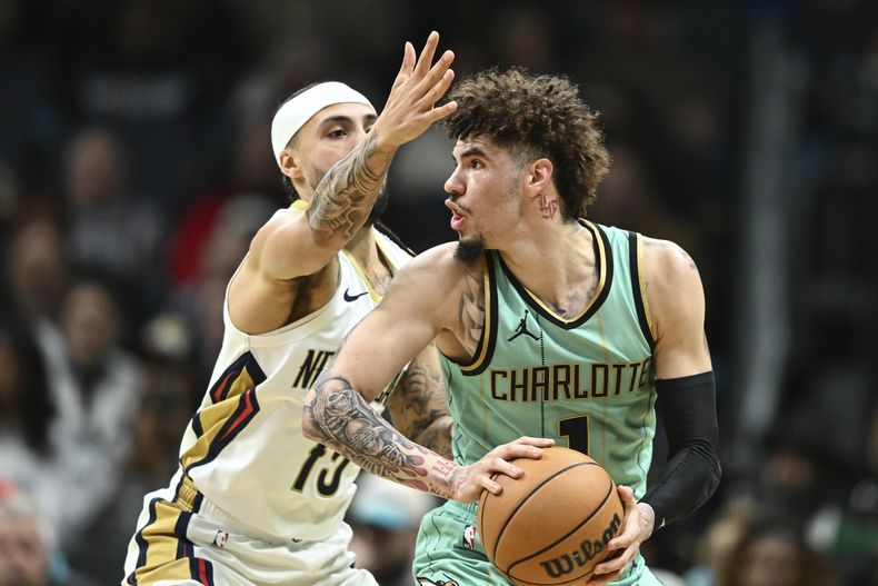 El escolta de los Hornets de Charlotte, LaMelo Ball (1), es defendido por el escolta de los Pelicans de Nueva Orleans, José Alvarado (15), durante la primera mitad de un partido de baloncesto de la NBA, el sábado 25 de enero de 2025, en Charlotte, Carolina del Norte (AP Foto/Matt Kelley)