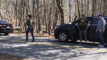 Una persona con un chaleco del FBI camina por una carretera el jueves 13 de abril de 2023, en North Dighton, Massachusetts. El FBI detuvo a un miembro de la Guardia Nacional Aérea de Massachusetts en relación con la filtración de información militar altamente confidencial sobre la guerra de Ucrania. (AP Foto/Jennifer McDermott)