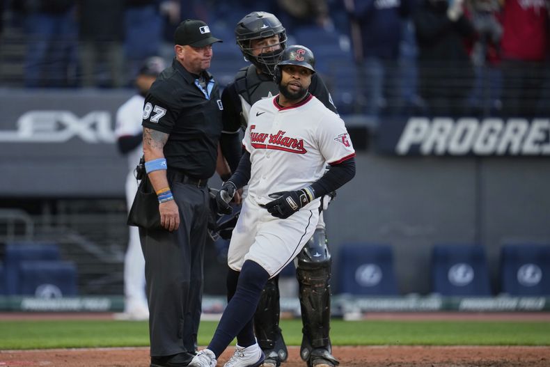 El dominicano Carlos Santana anota por los Guardianes de Cleveland frente al receptor Matt Thaiss de los Medias Blancas de Chicago, gracias a una base por bolas, el martes 8 de abril de 2025 (AP Foto/Sue Ogrocki)