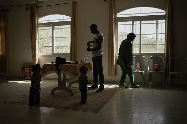 Una familia en un salón de bodas de un centro de caridad que se ha utilizado como refugio temporal para personas desplazadas en la ciudad cisjordana de Anabta, el jueves 3 de abril de 2025. (AP Foto/Leo Correa)