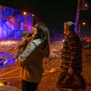Personas observan cómo socorristas trabajan para extinguir un incendio tras un ataque ruso en Kiev, Ucrania, el martes 25 de noviembre de 2025. (AP Foto/Dan Bashakov)