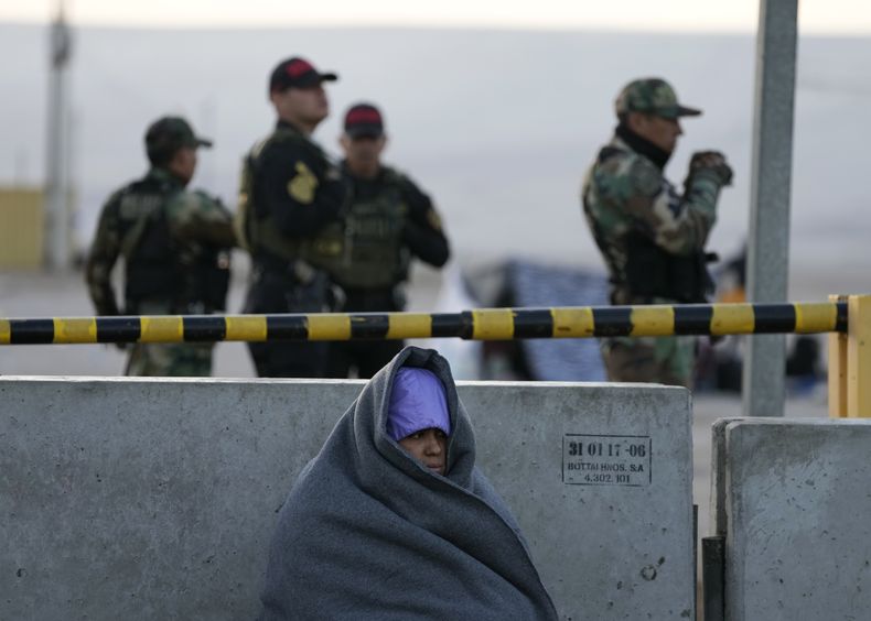 Un migrante espera en el frío en la frontera, sin poder cruzar de Chile a Perú, en Tacna, Perú, el viernes 28 de abril de 2023. (AP Foto/Martín Mejía)