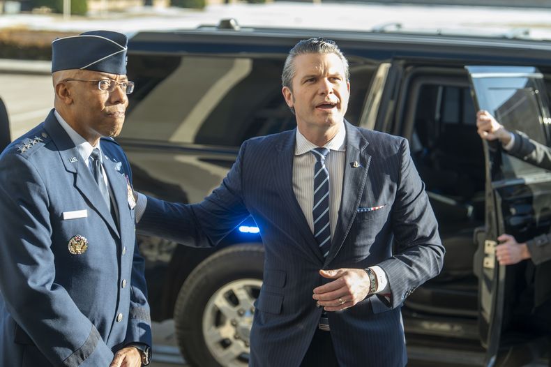 El secretariol de Defensa de Estados Unidos, Pete Hegseth (derecha), da una palmada en la espalda al jefe del Estado Mayor Conjunto, el general Charles Q. Brown Jr., mientras responde a reporteros a su llegada al Pentágono, el 27 de enero de 2025, en Washington. (AP Foto/Kevin Wolf)