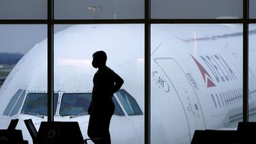 ARCHIVO - Un pasajero espera un vuelo de Delta Airlines en el Aeropuerto Internacional Hartsfield-Jackson en Atlanta el 18 de febrero de 2021. (AP Foto/Charlie Riedel, Archivo)