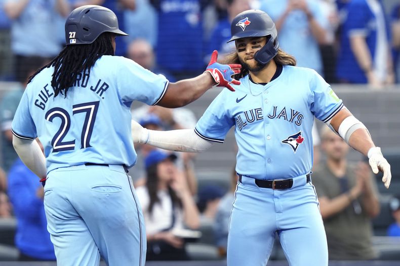 Bo Bichette, de los Azulejos de Toronto, a la derecha, celebra su jonrón de dos carreras contra los Medias Blancas de Chicago con Vladimir Guerrero Jr. (27) durante la segunda entrada de un juego de béisbol el miércoles 22 de mayo de 2024, en Toronto. (Frank Gunn/The Canadian Press vía AP)