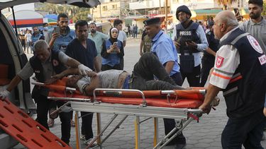 En esta imagen de archivo, reporteros observan mientras un palestino herido en un bombardeo israelí es llevado a un hospital en Deir el-Balah, en la Franja de Gaza, el 16 de octubre de 2023. El limitado número de periodistas que están en Gaza tratan de informar sobre la guerra con Israel mientras sufren los mismos problemas que la asediada población palestina de la Franja. (AP Foto/Adel Hana, archivo)
