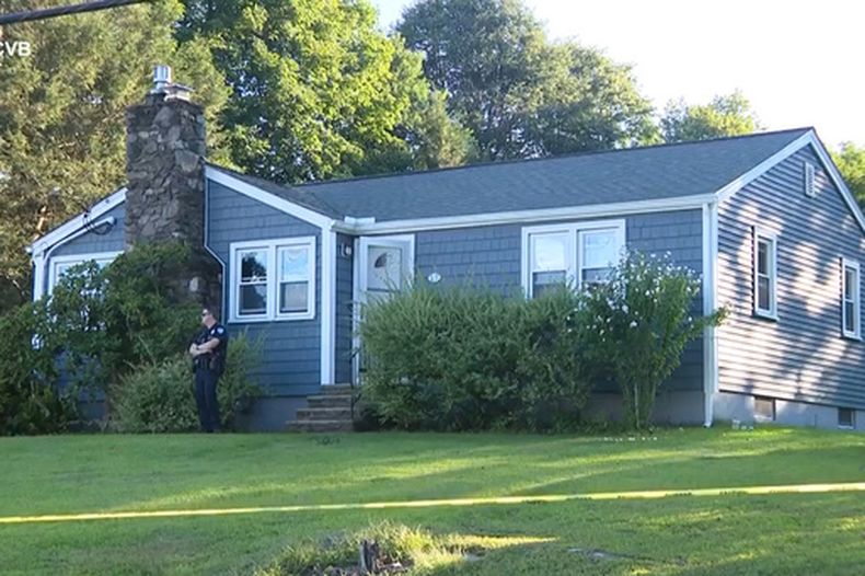 Esta captura de pantalla, tomada de un video proporcionado por WCVB-TV, muestra a un policía vigilando una casa en Worcester, Massachusetts, el martes 18 de agosto de 2026. (WCVB-TV vía AP)