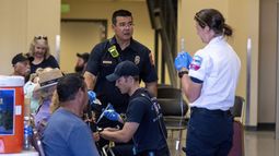 Bomberos y paramédicos atienden a personas afectadas por el calor durante un espectáculo aéreo el sábado 17 de agosto de 2024 en Colorado Springs, Colorado. (Parker Seibold/The Gazette vía AP)