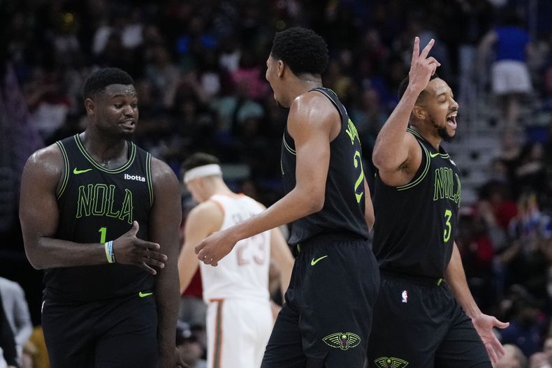 El armardor de los Pelicans de Nueva Orleans Trey Murphy III (25) celebra su triple junto al base CJ McCollum (3) y el alero Zion Williamson (1) en la segunda mitad del juego de NBA ante los Spurs de San Antonio en Nueva Orleans, el viernes 1 de diciembre de 2023. (AP Foto/Gerald Herbert)