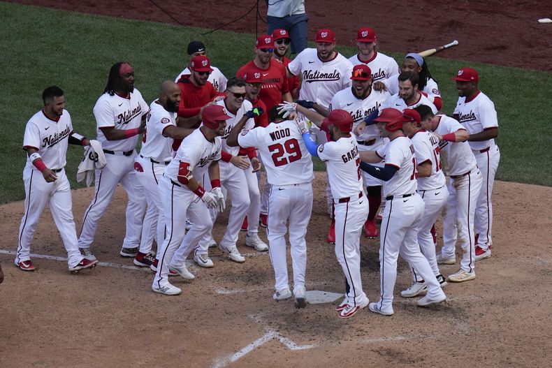 James Wood de los Nacionales de Washington celebra co su equipo en el plato tras su jonrón de la victoria en la undécima entrada ante los Rockies de Colorado el jueves 19 de junio del 2025. (AP Foto/Jess Rapfogel)
