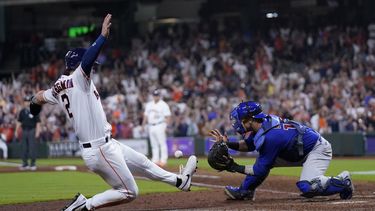 Alex Bregman, de los Astros de Houston, anota la carrera de la victoria frente al cátcher brasileño Yan Gomes, de los Cachorros de Chicago, el miércoles 17 de mayo de 2023 (AP Foto/David J. Phillip)