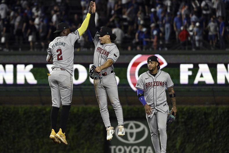 El dominicano Geraldo Perdomo (2) y el jardinero Alek Thomas saltan para celebrar la victoria sobre los Cachorros de Chicago, el sábado 20 de julio de 2024 (AP Foto/Matt Marton)