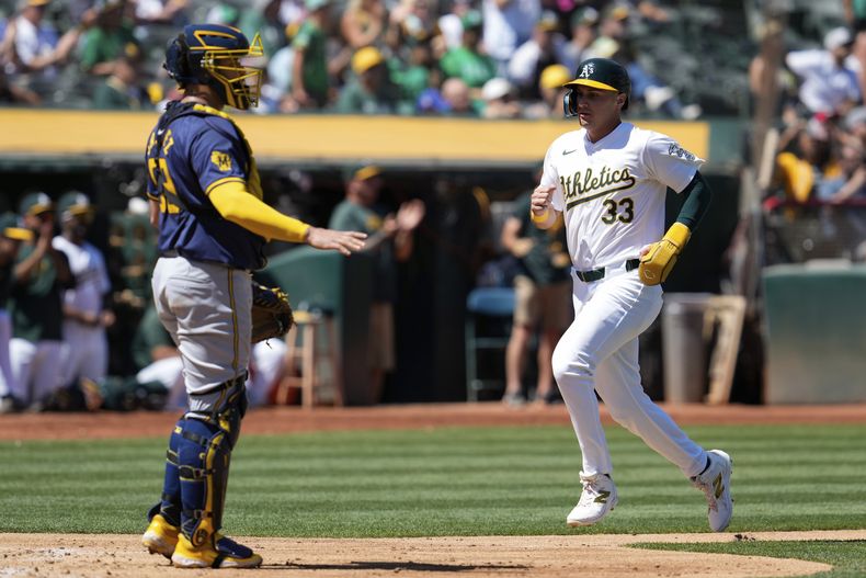 JJ BLeday (33) de los Atléticos de Oakland, anota en un elevado de sacrificio de Daz Cameron en el cuarto capítulo del juego de béisbol ante los Cerveceros de Milwaukee, el domingo 25 de agosto de 2024, en Oakland, California. (AP Foto/Godofredo A. Vásquez)