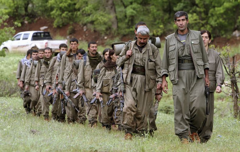 ARCHIVO - Un grupo de combatientes kurdos armados del Partido de los Trabajadores del Kurdistán (PKK) ingresa al norte de Irak en el área de Heror, al noreste de Dahuk, a 430 kilómetros (260 millas) al noroeste de Bagdad, Irak, el 14 de mayo de 2013. (AP Foto/Ceerwan Aziz, Archivo)