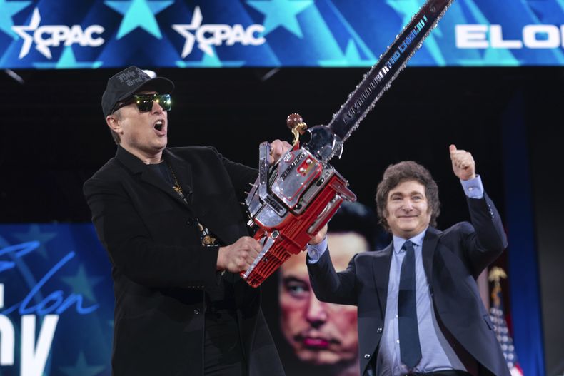 Elon Musk, a la izquierda, recibe una sierra eléctrica del presidente de Argentina, Javier Milei, a su llegada a la Conferencia de Acción Política Conservadora (CPAC, por sus siglas en inglés) en el Gaylord National Resort & Convention Center, el jueves 20 de febrero de 2025, en Oxon Hill, Maryland. (AP Foto/José Luis Magaña)