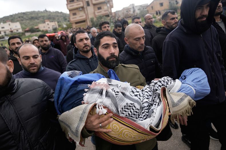 Un hombre palestino lleva en brazos el cuerpo de Muhammad Bani Odeh, de 5 años, en el funeral de cuatro miembros de la familia Odeh asesinados en su auto por fuerzas de seguridad israelíes durante una operación militar en Tammun, Cisjordania, el domingo 15 de marzo de 2026. (AP Foto/Majdi Mohammed)
