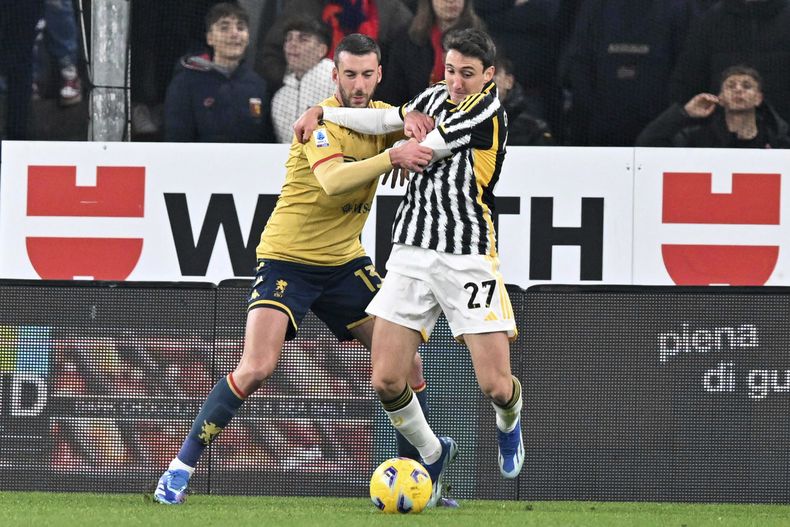 Andrea Cambiasso (derecho) de la Juventus, y Mattia Bani (izquierda) del Genoa disputan el balón durante el partido de la Liga Italiana en el estadio Luigi Ferraris en Genoa, Italia, el viernes 15 de diciembre de 2023. (Tano Pecoraro/LaPresse via AP)