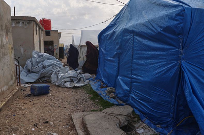 ARCHIVO - Mujeres no identificadas caminan ente carpas en una sección del campamento que aloja a familiares australianos de supuestos milicianos del grupo Estado Islámico en el campamento de Roj, en el este de Siria, el 18 de febrero de 2026. (AP Foto/Baderkhan Ahmad, Archivo)