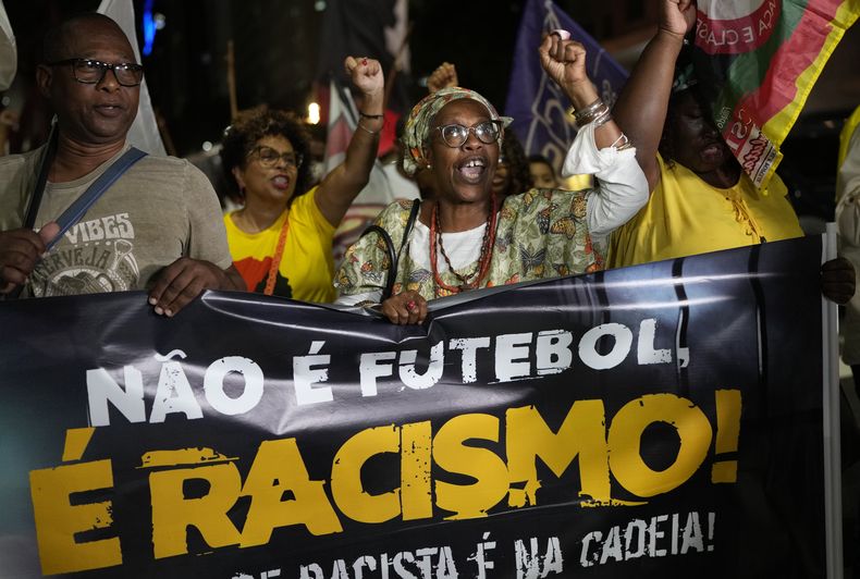 Gente sostiene la pancarta con la leyenda No es fútbol, es racismo en portugués durante una protesta en Río de Janeiro por los insultos racistas contra Vinicus Júnior en la liga española, el jueves 25 de mayo del 2023. (AP Foto/Silvia Izquierdo)