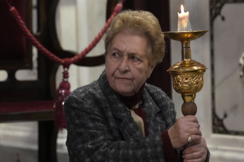 Una mujer siria cristiana asiste a la primera misa desde la caída del presidente, Bashar Assad, en la iglesia ortodoxa Mariamiya en la zona antigua de Damasco, Siria, el domingo 15 de diciembre de 2025. (AP Foto/Hussein Malla)