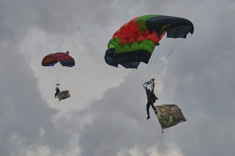 Paracaidistas izan imágenes del expresidente Fidel Castro en una celebración por su cumpleaños, en La Habana, el martes 12 de agosto de 2025. (Foto AP/Ramon Espinosa)