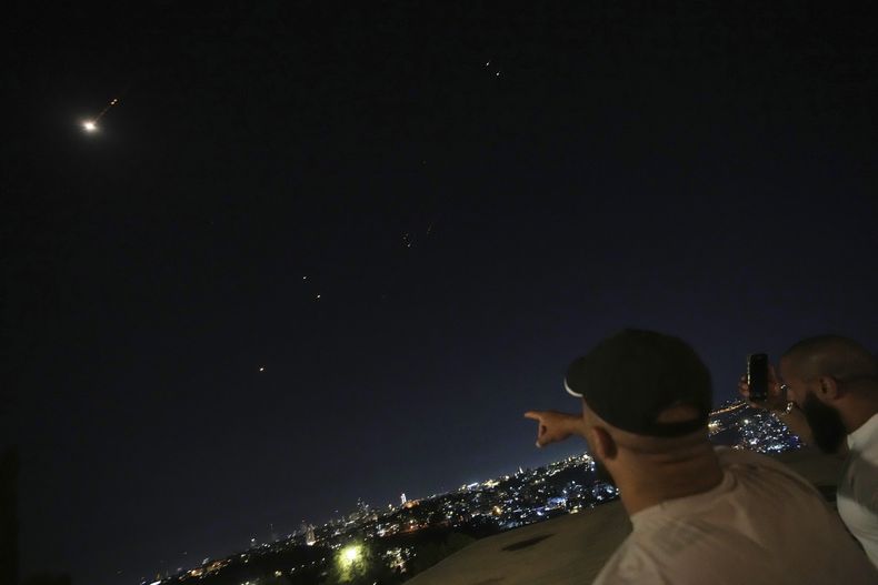 Personas observan estelas sobre Jerusalén durante un ataque con misiles, el viernes 13 de junio de 2025. (AP Foto/Ohad Zwigenberg)