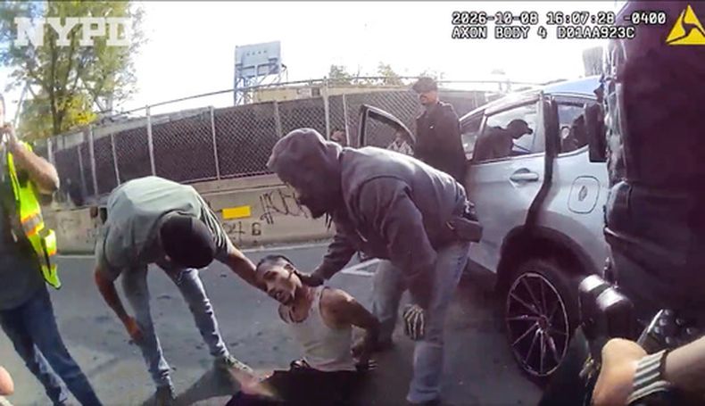 En esta imagen, extraída de un video grabado por la cámara corporal de un agente y difundido por el Departamento de Policía de Nueva York (NYPD), agentes atienden a Oscar Belgal, un dominicano de 28 años que fue baleado por agentes federales de inmigración el jueves 8 de octubre de 2026 en Nueva York, cuando conducía su vehículo con un niño de 5 años a bordo. (NYPD vía AP)