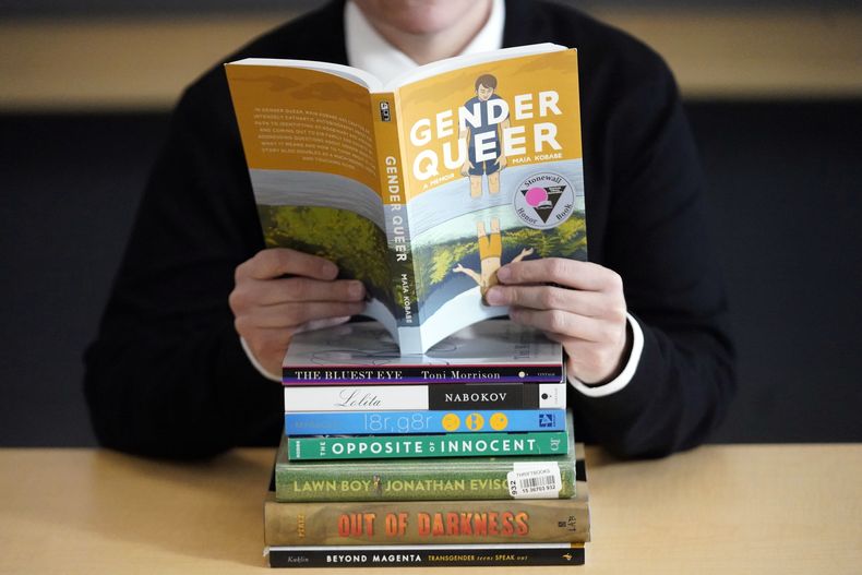 Amanda Darrow, directora de programas educativos y familiares del Utah Pride Center, posa con libros que han sido criticados por padres, incluyendo Gender Queer por Meir Kobabe, el 16 de diciembre de 2021, en Salt Lake City. (AP foto/Rick Bowmer)