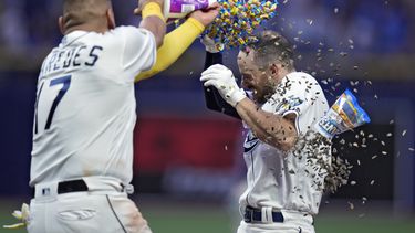 El mexicano Isaac Paredes, de los Rays de Tampa Bay, arroja goma de mascar y semillas de girasol a Brandon Lowe, quien bateó el sencillo del triunfo ante los Rockies de Colorado, el miércoles 23 de agosto de 2023 (AP Foto/Chris OMeara)