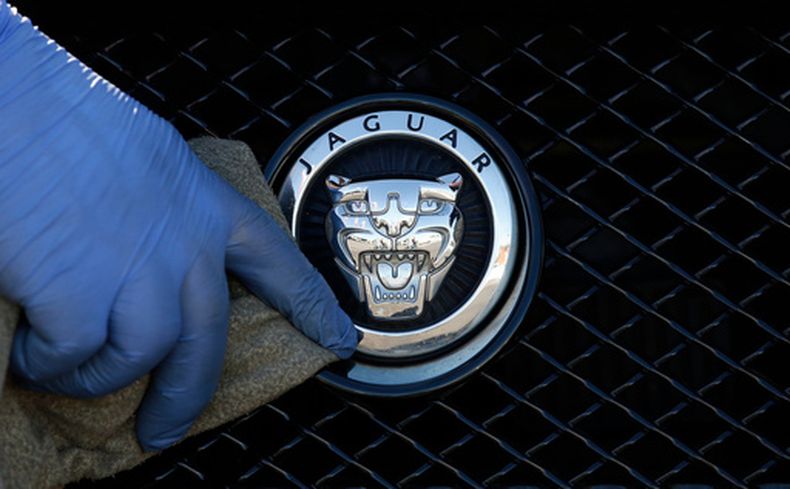 Un trabajador pule el logo de un vehículo Jaguar en un concesionario en Londres, el 28 de septiembre de 2016. (Foto AP/Frank Austin, Archivo)
