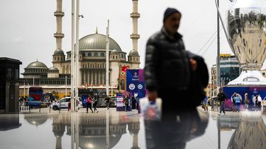 Peatones caminan a un costado de un enorme trofeo de la Liga de Campeones en Taksim square, en Estambul, el jueves 8 de junio de 2023. Manchester City jugará contra Inter de Milán la final de la Liga de Campeones el sábado 10 de junio en Estambul. (AP Foto/Francisco Seco)