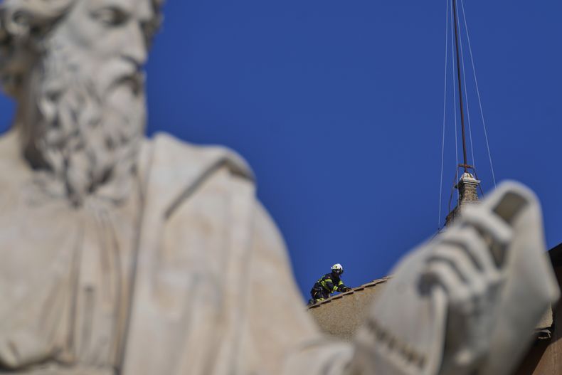 Bomberos instalan una chimenea en el tejado de la Capilla Sixtina, donde los cardenales se reunirán para elegir al nuevo papa, en el Vaticano, el 2 de mayo de 2025. (AP Foto/Gregorio Borgia)